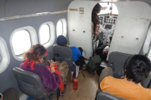 Youth sit inside the floatplane, looking out the windows and preparing for flight.