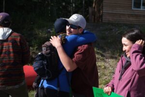 Community members welcome back participants with hugs and smiles.