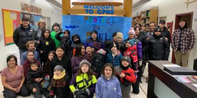 Gathered youth and community members for the Peel smile inside Chief Paul Niditchie School in Tsiigehtchic, NWT. Gwichya Gwich'in First Nation traditional territory, photo by Fredrick-Sonny Blake.