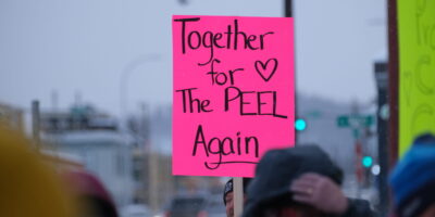 Close-up of a bright pink sign at the rally in Whitehorse that reads, "Together for the Peel Again" with a hand-drawn heart. Kwanlin Dün First Nation and the Ta’an Kwäch’än Council traditional territory, photo by Adil Darvesh.