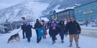 People march outside in Dawson, YT at the Protect the Peel rally, holding signs and banners with messages like "Off the Peel.” Tr'ondëk Hwëch'in traditional territory, photo by Sharon Vittrekwa.