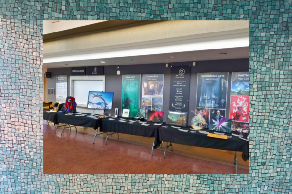 Row of tables showcases auction fundraiser items, including several landscape photography prints. Kwanlin Dün First Nation and the Ta’an Kwäch’än Council traditional territory, photo by Chris Pinkerton.